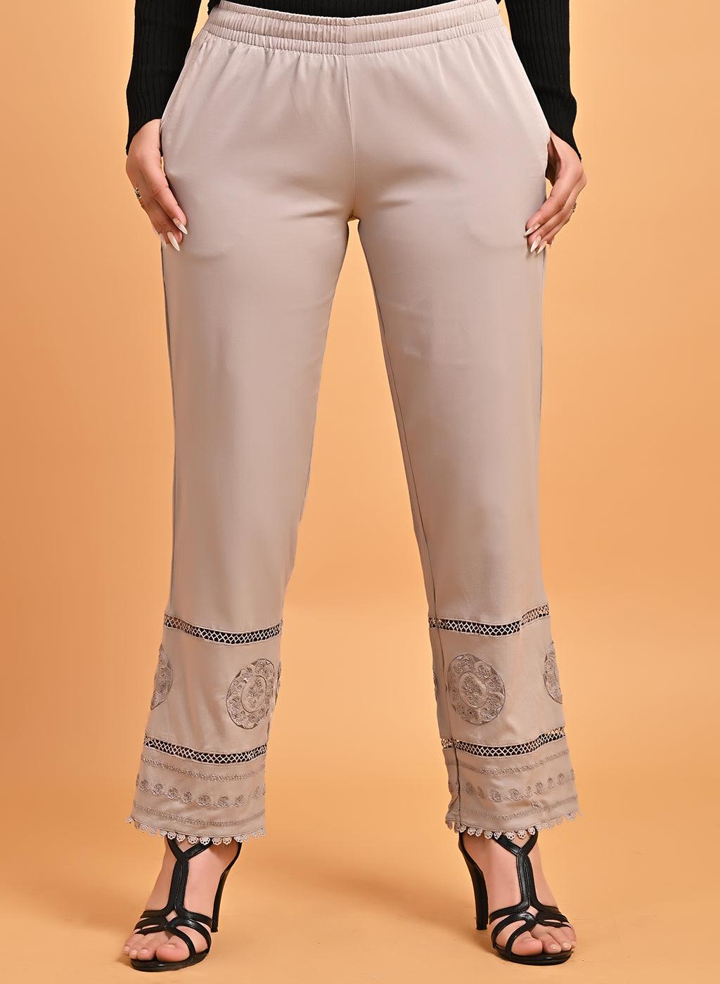 White cotton pants with embroidered detailing at hem by Free Living