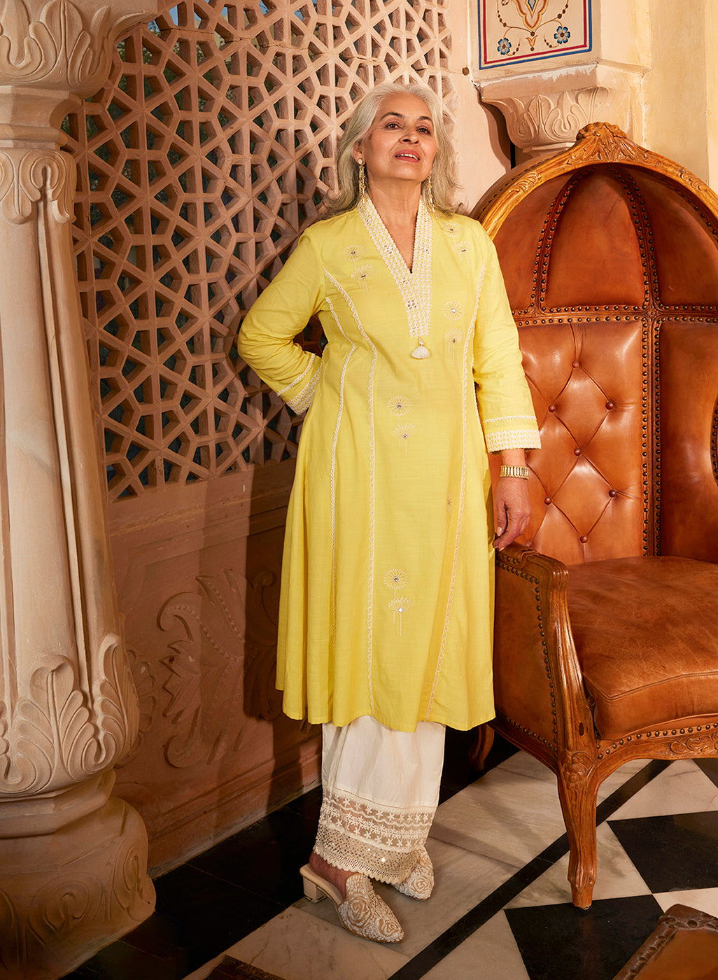 An old woman posing in Zainab Lemon Embroidered Cotton Linen Indo-western Dress and embroidered palazzos