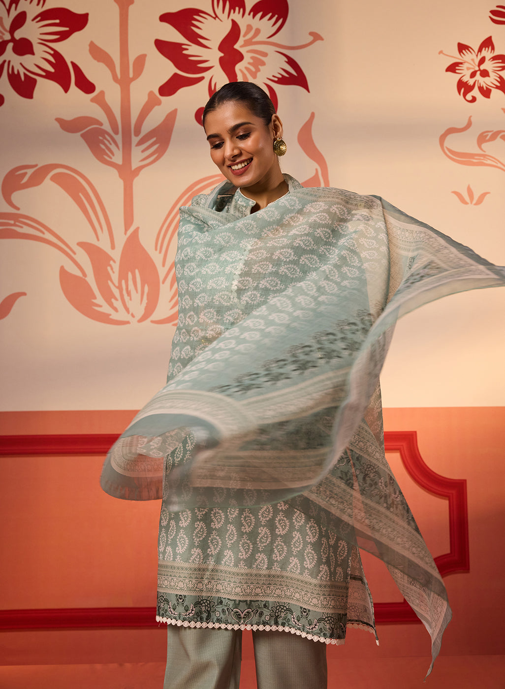 A woman wearing Fiona Aqua Printed Cotton Linen Set while twirling the Dupatta