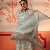 A woman wearing Fiona Aqua Printed Cotton Linen Set while twirling the Dupatta