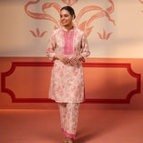 Roshna Coral Printed Cotton Linen Kurta Set hanging with a floral backdrop