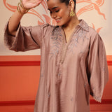 A woman wearing a Niya Oak Brown Embroidered Cotton Linen Slub Long Top