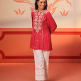 Woman in a Kashaf Crimson Pink Embroidered Crinkled Crepe Long Top paired with white palazzos