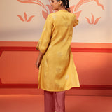 Woman walking away in Rumi Bright Yellow Printed Tunic Set paired with embroidered pumps