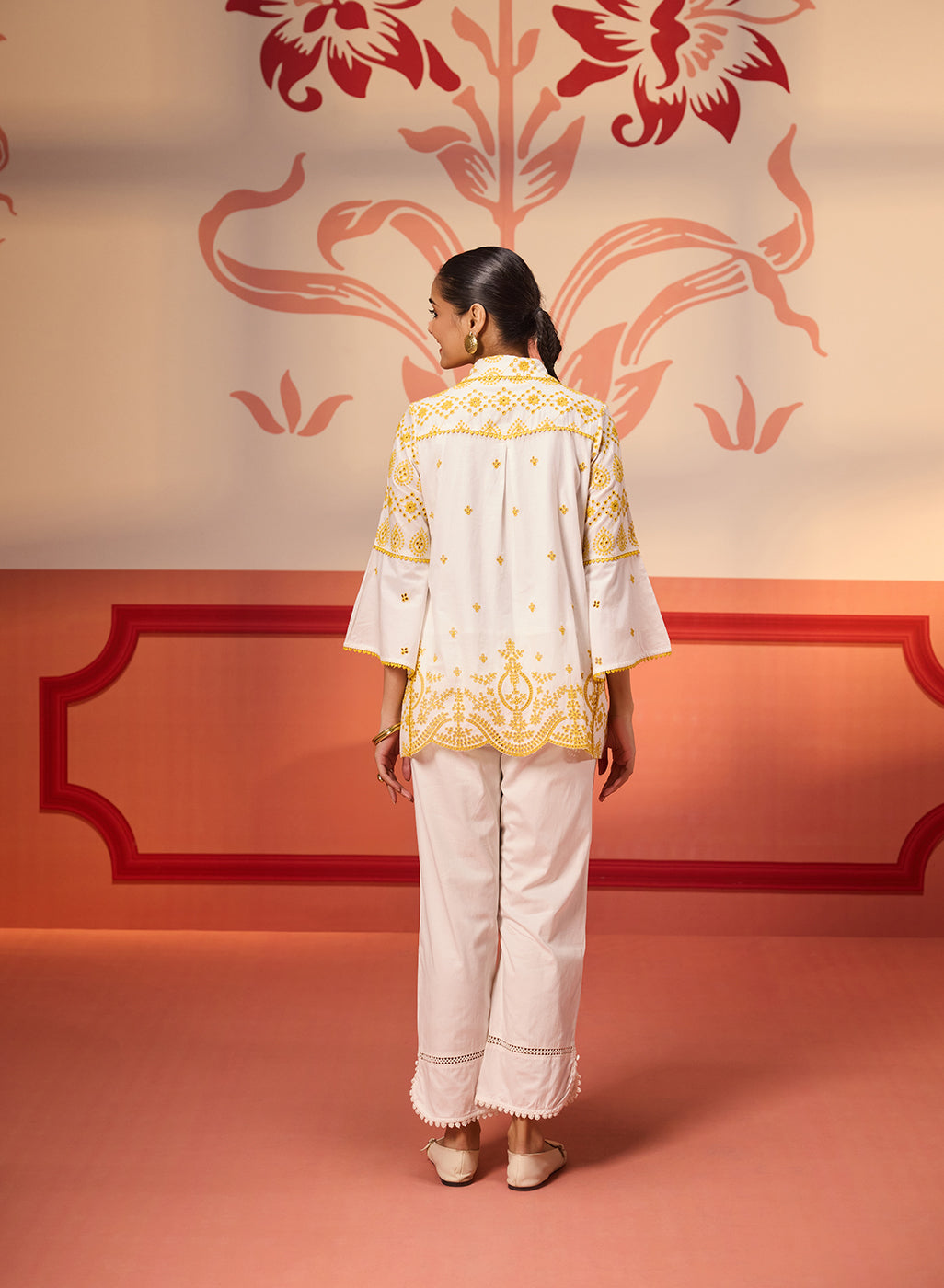 Back view of a woman wearing Masakali Ivory with a Yellow Embroidered Schiffli Shirt paired with white bottoms