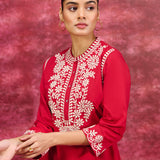 A stylish woman wearing an elegant Saadgi red cotton linen tunic with white embroidery on front and sleeves